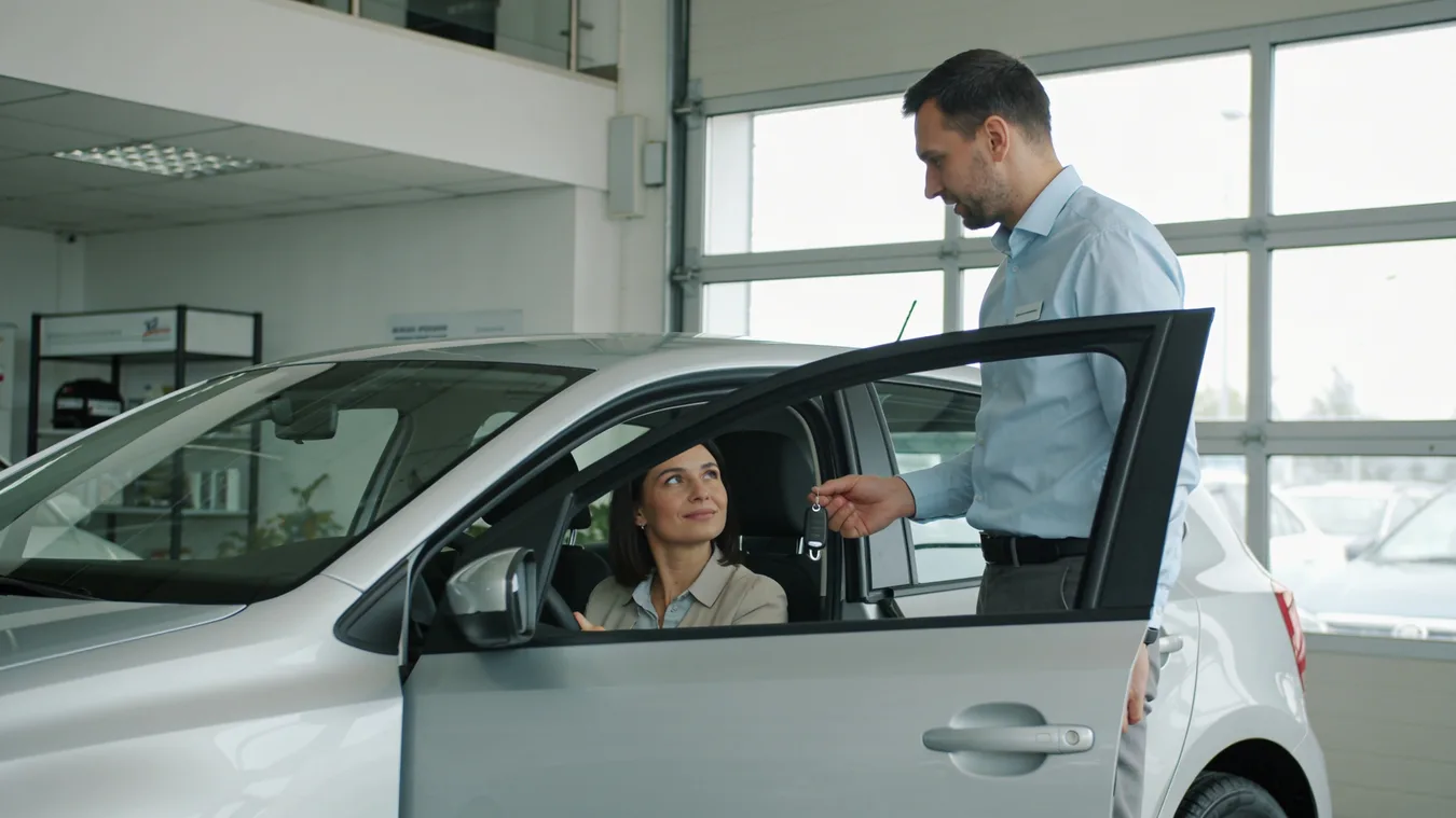 Kupujúca skúša auto v predajni so sprievodom predajcu