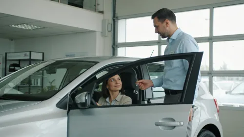 Kupujúca skúša auto v predajni so sprievodom predajcu
