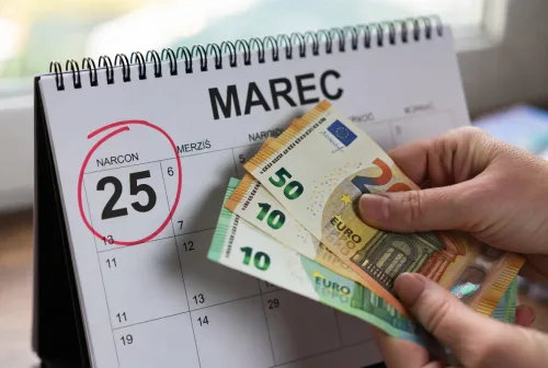 Ruky držiace kalendár a peniaze - Pôžička do výplaty