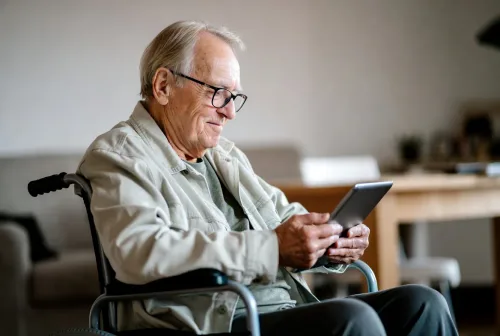 Starší muž s barlami pri bankomate - Pôžička pre invalidných dôchodcov