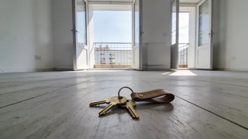 Rodina stojaca pred novým rodinným domom s krabicami pripravená na sťahovanie