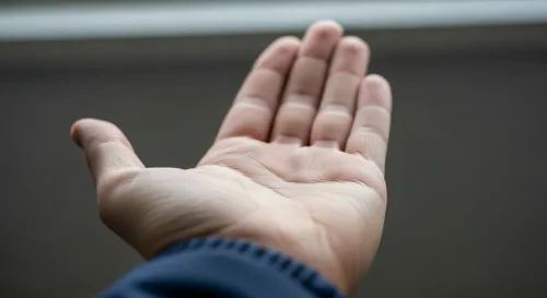 Otvorená dlaň pri stole ako motív povery o peniazoch